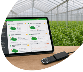 ハウス内でタブレットのAgriwareダッシュボードとセンサー機器（ELTRES子機）を確認している様子の写真
